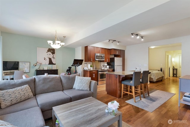 living room with dark hardwood / wood-style flooring, a chandelier, and sink