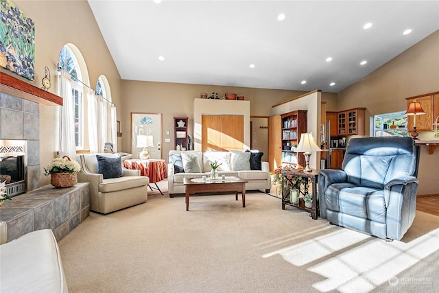 living room with high vaulted ceiling, light carpet, and a fireplace