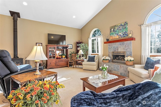 carpeted living room featuring a wood stove, lofted ceiling, and a healthy amount of sunlight