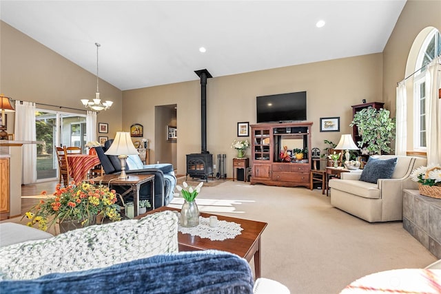 living room with light carpet, a chandelier, a wood stove, and high vaulted ceiling