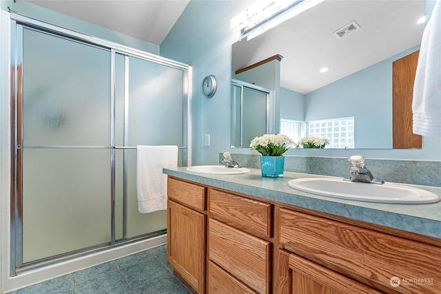 bathroom with a shower with shower door, tile patterned flooring, vanity, and vaulted ceiling