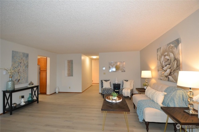 living room featuring a textured ceiling and light wood-style floors