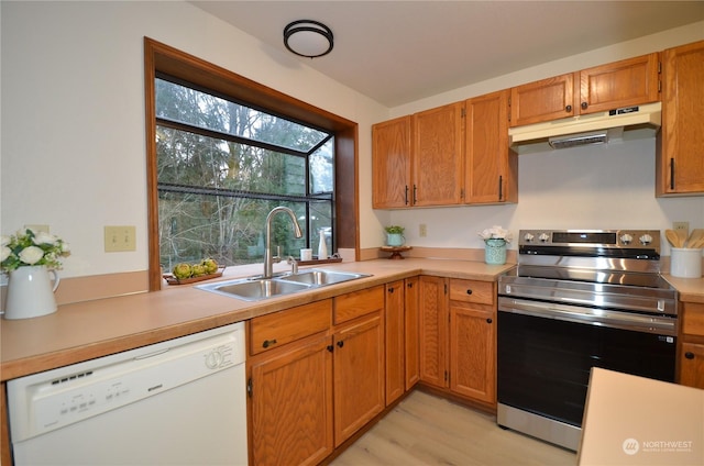 kitchen with white dishwasher, under cabinet range hood, electric range, a sink, and light countertops