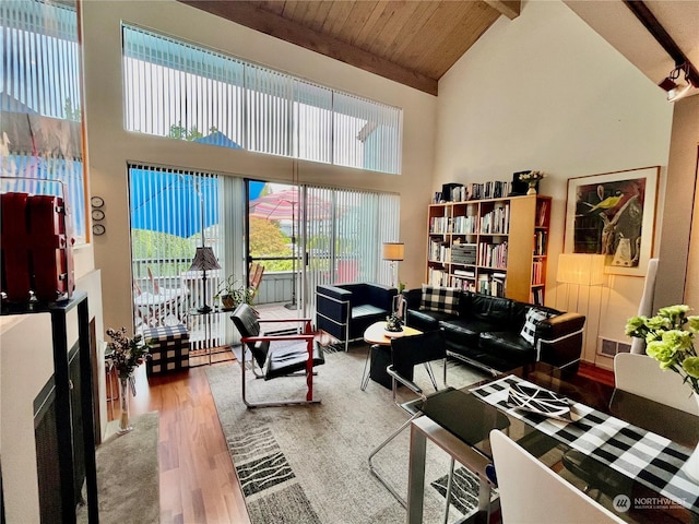 living room featuring a wealth of natural light, beam ceiling, hardwood / wood-style flooring, and high vaulted ceiling