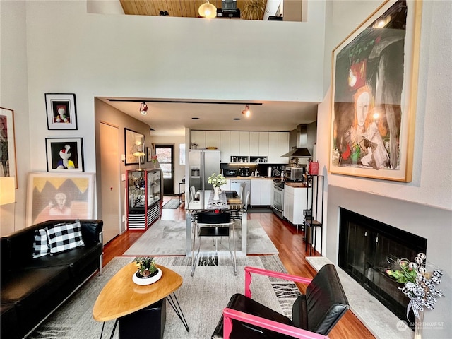 living room featuring hardwood / wood-style flooring, rail lighting, and wooden ceiling