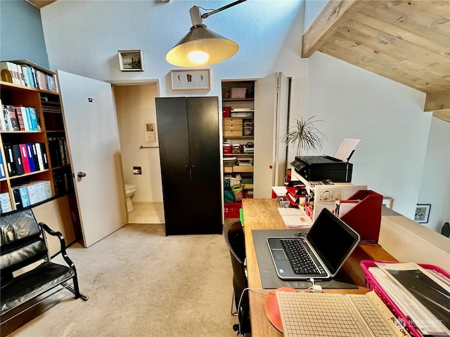 office area featuring light carpet and vaulted ceiling with beams