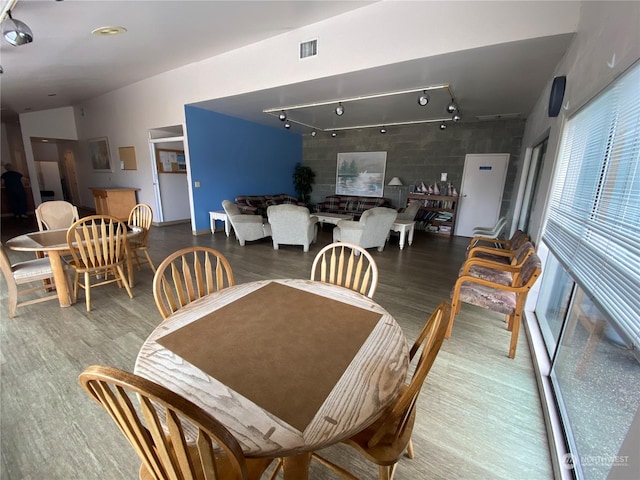 dining room with wood-type flooring and track lighting