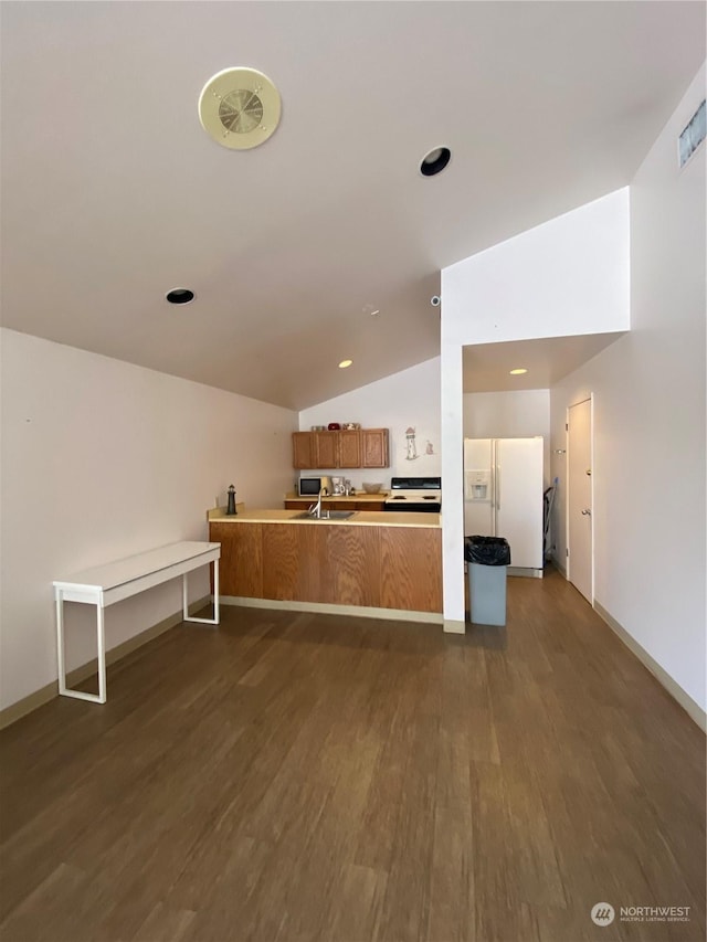 kitchen with kitchen peninsula, dark hardwood / wood-style flooring, lofted ceiling, white refrigerator with ice dispenser, and sink