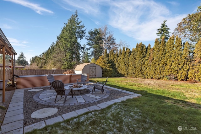 view of yard featuring a fire pit, a storage shed, and a patio