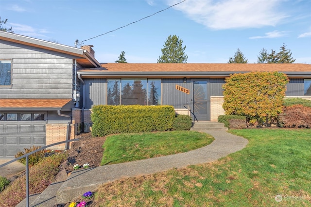 view of front of house with a garage and a front yard