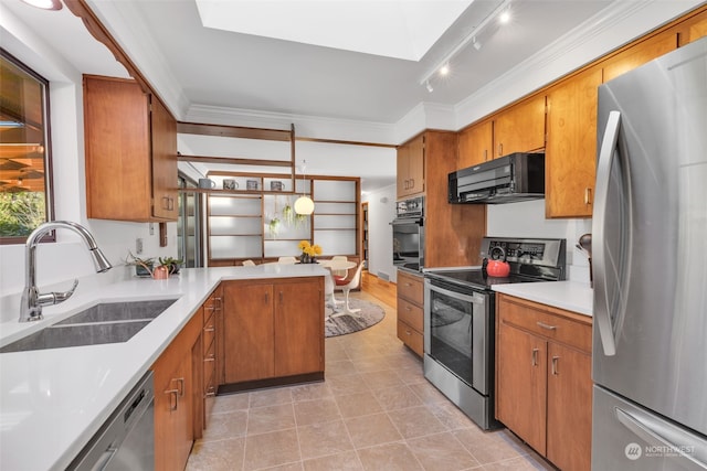 kitchen with black appliances, a skylight, sink, kitchen peninsula, and pendant lighting