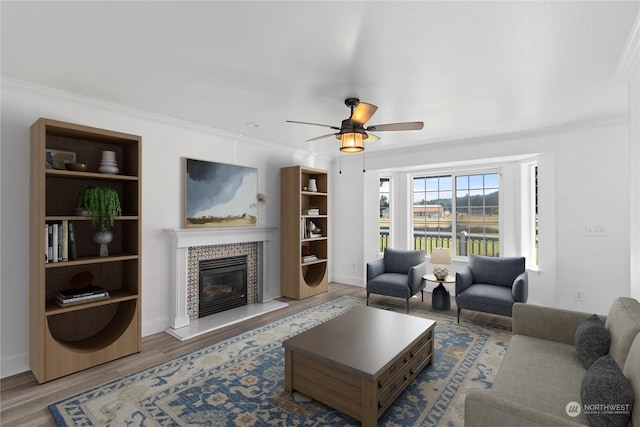 living room featuring crown molding, hardwood / wood-style flooring, and a tile fireplace