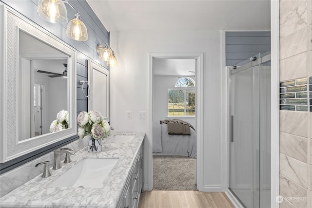 bathroom featuring wood-type flooring, a shower with door, and vanity