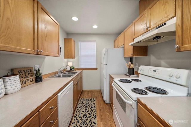 kitchen featuring sink, white appliances, and light wood-type flooring