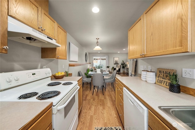 kitchen featuring white appliances, light hardwood / wood-style floors, sink, decorative light fixtures, and light brown cabinets