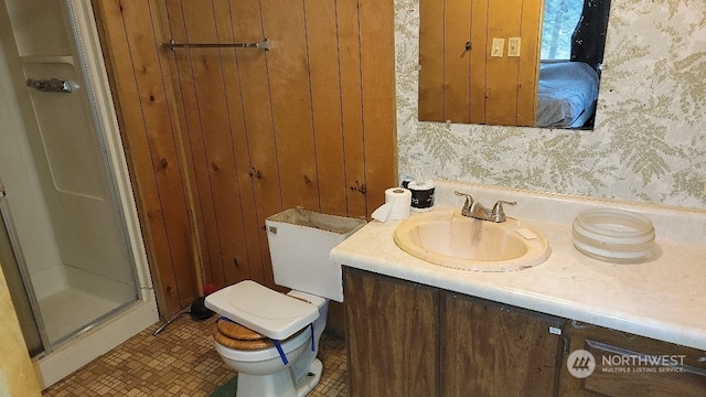 bathroom featuring vanity, toilet, and a shower with shower door