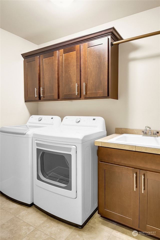 washroom with cabinets, separate washer and dryer, and sink