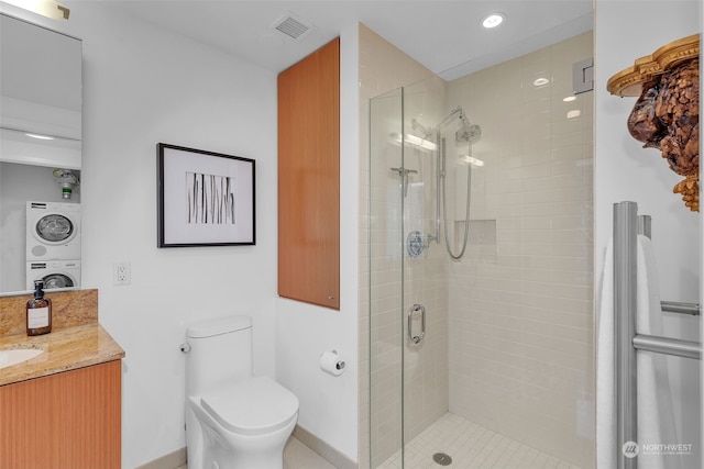 bathroom with toilet, a shower with door, stacked washing maching and dryer, and vanity