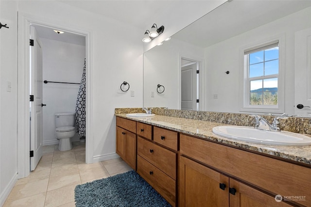 bathroom featuring toilet, vanity, and tile patterned flooring