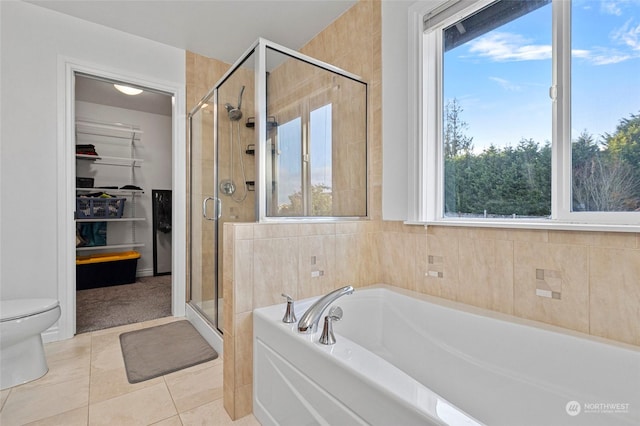 bathroom with toilet, tile patterned flooring, and plus walk in shower