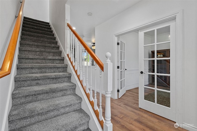 stairs with ceiling fan and wood-type flooring