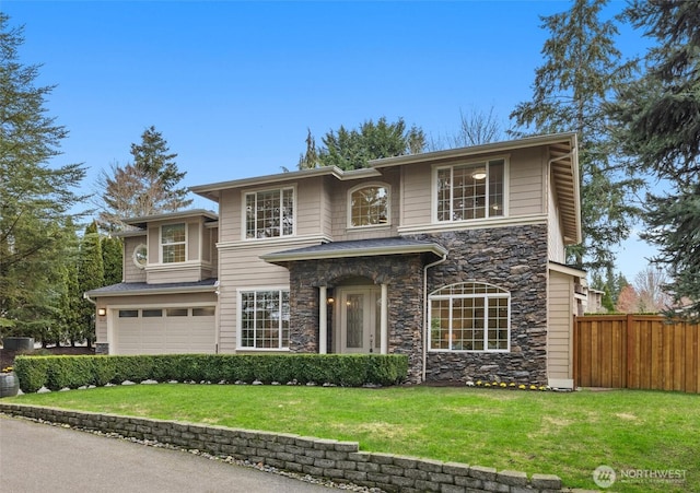 traditional-style home featuring stone siding, an attached garage, a front yard, and fence