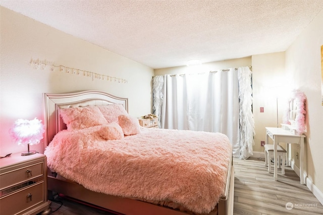 bedroom featuring a textured ceiling and hardwood / wood-style flooring