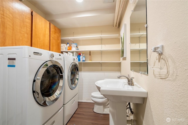 clothes washing area with dark wood-type flooring and washer and clothes dryer