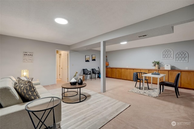 carpeted living room featuring a textured ceiling