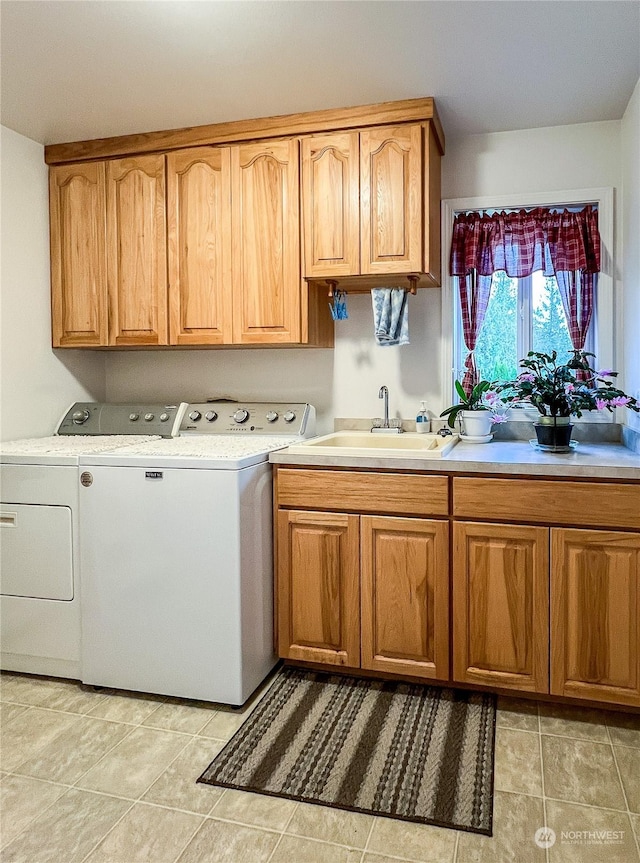 clothes washing area featuring cabinets, sink, washer and clothes dryer, and light tile patterned flooring