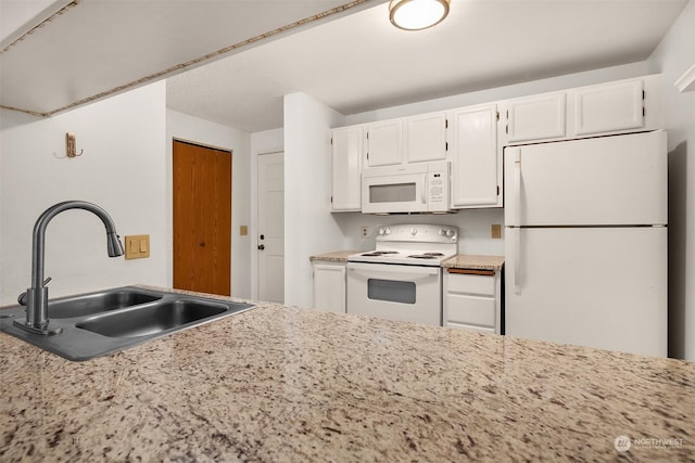 kitchen featuring sink, white appliances, and white cabinets