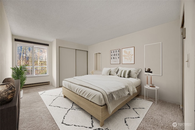 carpeted bedroom featuring a closet, a textured ceiling, and baseboard heating