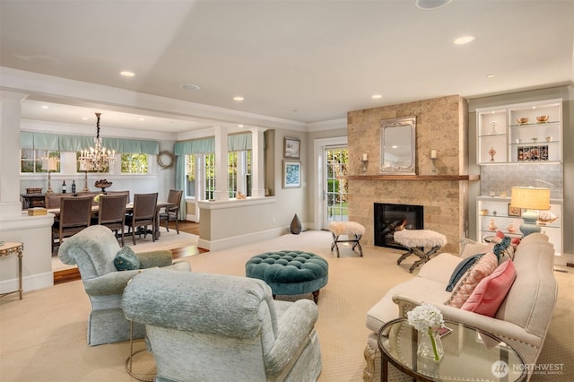 carpeted living room featuring recessed lighting, a large fireplace, crown molding, baseboards, and a chandelier