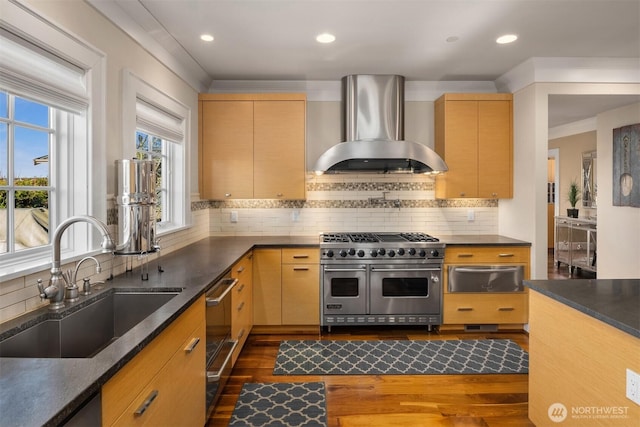 kitchen featuring range with two ovens, a sink, dark countertops, a warming drawer, and wall chimney exhaust hood