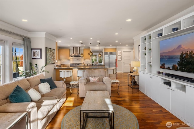 living area with recessed lighting, dark wood-style floors, and ornamental molding