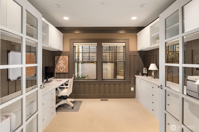 office space featuring light carpet, built in desk, and recessed lighting