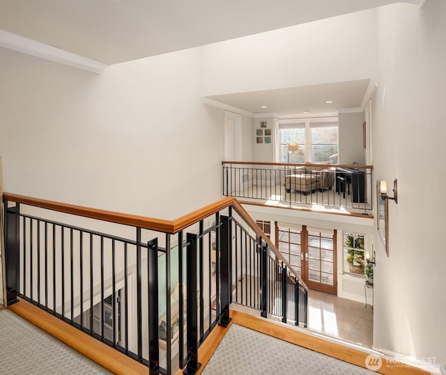 stairs with crown molding and a high ceiling