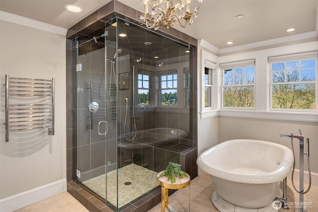 bathroom featuring a notable chandelier, radiator, a stall shower, and a freestanding tub