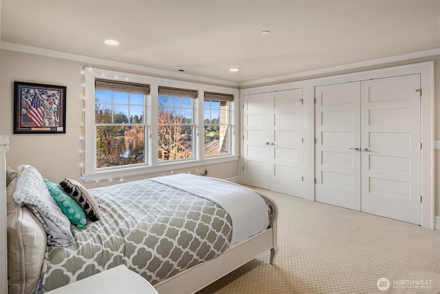 bedroom with carpet flooring, recessed lighting, multiple closets, and ornamental molding