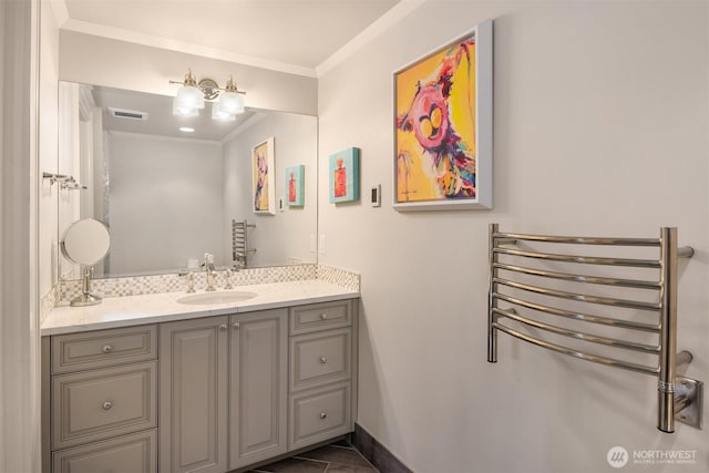 bathroom with visible vents, vanity, crown molding, and baseboards