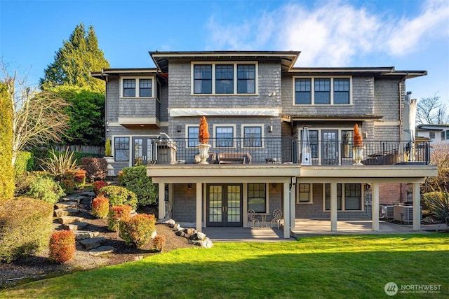 rear view of house featuring a patio area, a yard, and french doors