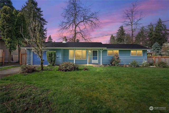 single story home featuring a yard and a garage