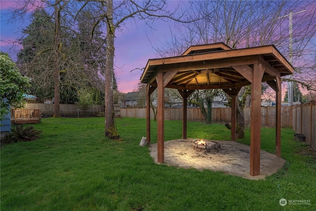 yard at dusk with an outdoor fire pit and a gazebo