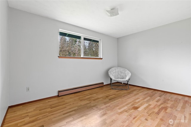 empty room with light hardwood / wood-style flooring and a baseboard radiator