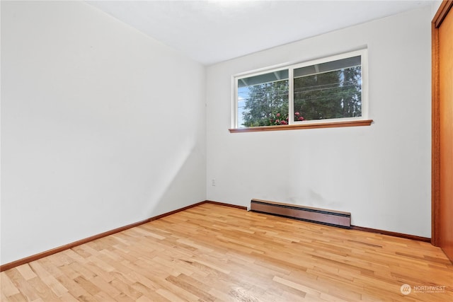 empty room with light wood-type flooring and baseboard heating