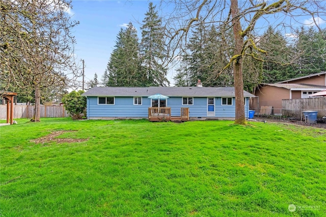 back of house with a wooden deck and a yard