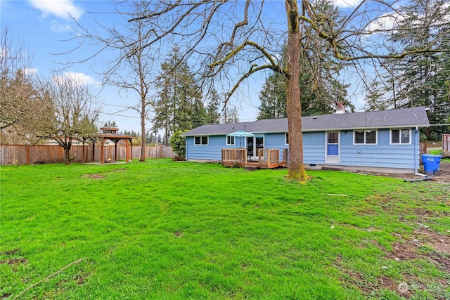 rear view of house with a deck and a lawn