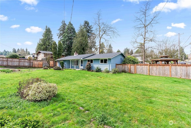 back of house with a gazebo and a yard