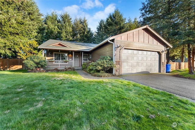 view of front of property featuring a garage, a front yard, and a porch