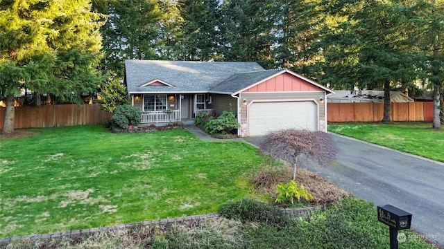 view of front of home with a front yard, a porch, and a garage